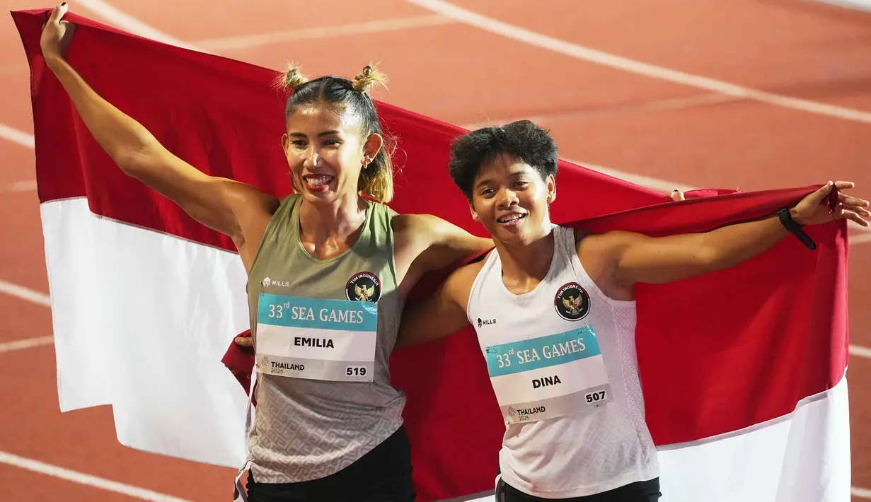Dina Aulia dan Emilia Nova sukses meraih medali emas dan perak pada lomba yang berlangsung di Suphachalasai Stadium, Pathum Wan, Bangkok, Jumat 12 Desember 2025. Tampak dalam foto, atlet lari gawang putri Indonesia, Dina Aulia (kanan) bersama Emilia Nova merayakan kemenangannya setelah memenangkan final lari gawang 100 meter putri di SEA Games ke-33 di Bangkok, Thailand, Jumat 12 Desember 2025. (AP Photo/ Achmad Ibrahim)