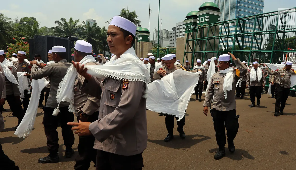 Personel Brimob yang tergabung dalam Pasukan Dzikir Asmaul Husna mengenakan sorban bersiap menjalankan salat di depan Gedung MPR/DPR, Senayan, Jakarta, Selasa (24/10). (Liputan6.com/JohanTallo)