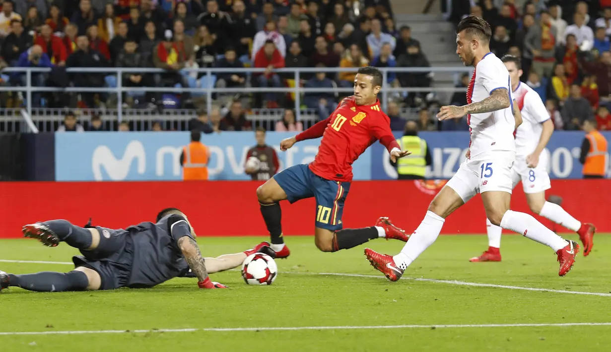 Kiper Kosta Rika, Danny Carvajal, coba menghentikan tendangan gelandang Spanyol, Thiago Alcantara, pada laga persahabatan di Stadion La Rosaleda, Sabtu (11/11/2017). Spanyol menang 5-0 atas Kosta Rika. (AP/Miguel Morenatti)