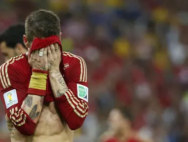 Pemain belakang Spanyol, Sergio Ramos, menutupi wajahnya usai dikalahkan Chile 0-2 di Stadion Maracana, Rio de Janeiro, Brasil, (19/6/2014). (REUTERS/Jorge Silva)