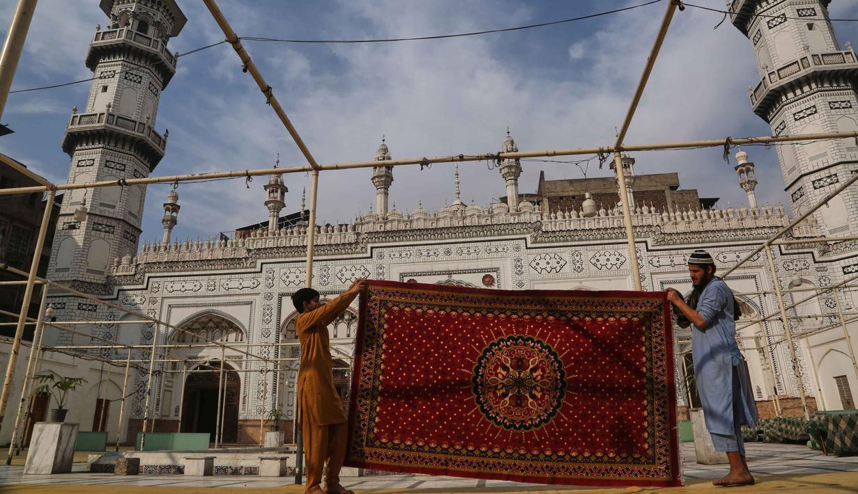 Sebagai pusat ibadah ikonik, masjid ini mempersiapkan suasana religius, termasuk perawatan menara dan gerbangnya, untuk menambah kekhusyukan selama bulan suci Ramadan. Tampak dalam foto, para pekerja membersihkan karpet di masjid bersejarah Mahabat Khan sebagai persiapan menyambut bulan puasa Ramadan, di Peshawar, Pakistan, Senin, 16 Februari 2026. (AP Photo/Muhammad Sajjad)