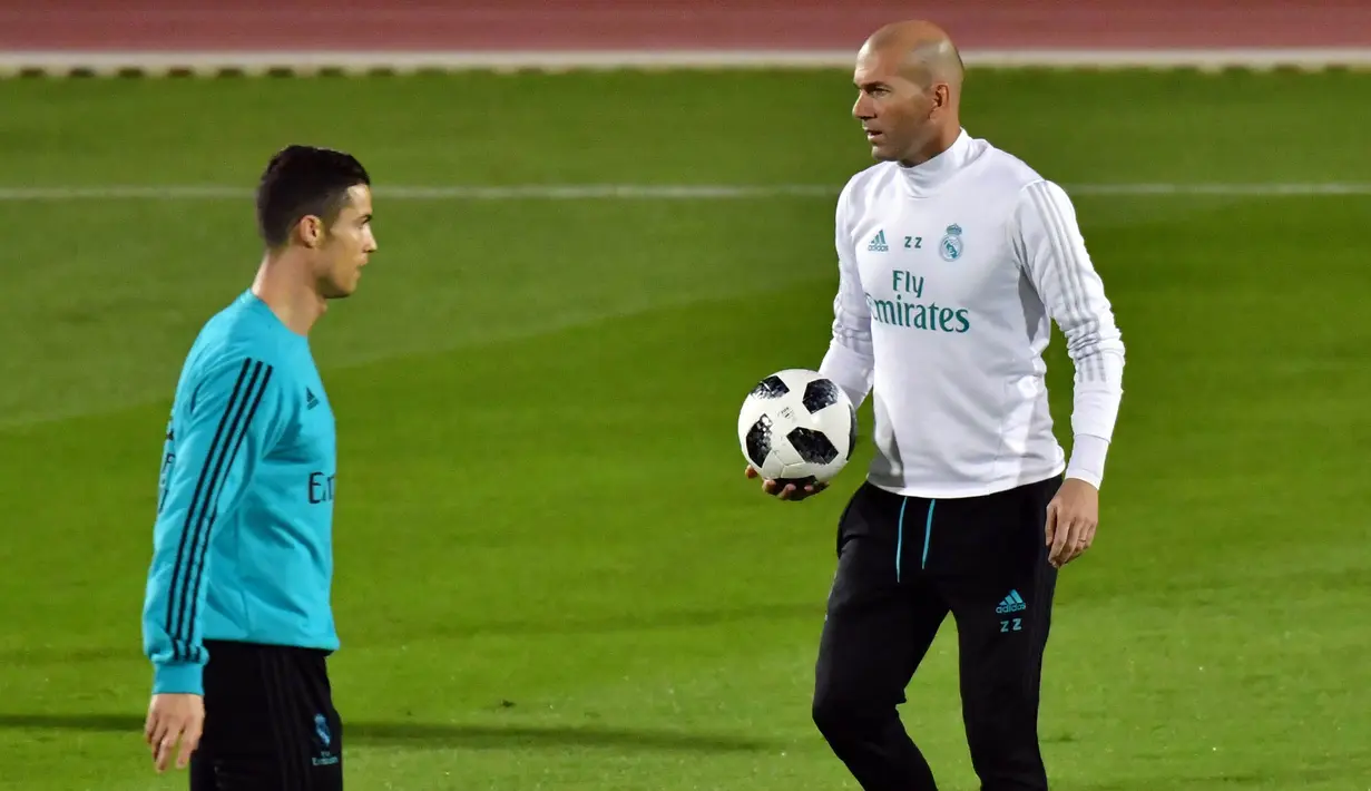 Pelatih Real Madrid, Zinedine Zidane, memberikan instruksi kepada Cristiano Ronaldo saat latihan di Stadion NY University Abu Dhabi, UAE, Senin (11/12/2017). Los Blancos bersiap jelang semifinal FIFA Club World Cup. (AFP/Giuseppe Cacace)
