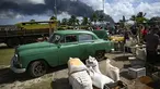 Warga Kuba membeli makanan di pasar pertanian saat terjadi kebakaran hebat di depot bahan bakar di Matanzas, Kuba (7/8/2022). Kuba meminta bantuan Sabtu (7/7) untuk mengatasi kebakaran besar yang menyebabkan 77 orang terluka dan 17 petugas pemadam kebakaran hilang. Sekitar 800 orang telah dievakuasi dari daerah tersebut. (AFP/Yamil Lage)