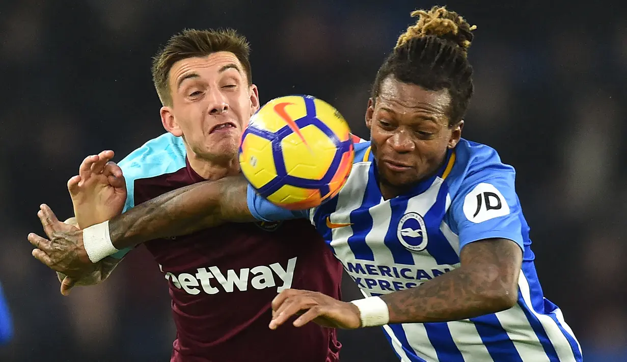 Bek Brighton and Hove Albion, Gaetan Bong (kanan) berebut bola dengan striker West Ham, Jordan Hugil pada laga Liga Inggris 2017/2018 di American Express Community Stadium, Brighton (3/2/2018). Gaetan Bong tampil di Premier League Liga Inggris bersama Brighton and Hove Albion selama 2,5 musim pada 2017/2018 hingga tengah musim 2019/2020. Sejatinya ia telah memperkuat Brighton sejak 2015/2016 saat masih berkompetisi di Championship. Di Premier League ia total tampil dalam 51 laga bersama Brighton. (AFP/Glyn Kirk)