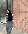 Padu padan plaid shirt dengan top hitam dan loose pants abu-abu sempurna untuk outfit kuliah.  [Instagram/adiba.knza]