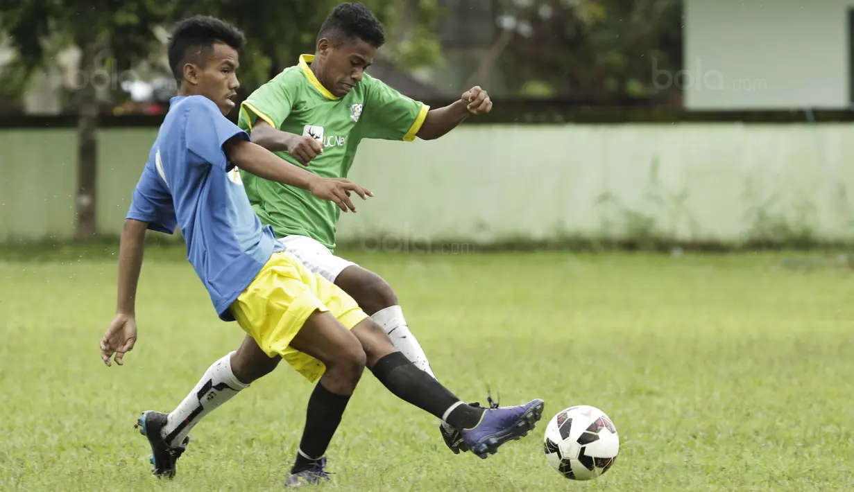 Pemain SSB Hatu berebut bola dengan pemain SSB Maehanu pada semifinal turnamen Liga Remaja UC News di Lapangan Masariku Yonif 733, Ambon, Rabu (29/11/2017). (Bola.com/Peksi Cahyo)
