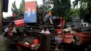 Petugas melakukan pengecekan bangkai armada truk sampah di Kantor Suku Dinas Lingkungan Hidup, Jakarta Barat, Selasa (27/3). Penumpukan armada tersebut dikarenakan kendaraan sudah tidak layak pakai. (Liputan6.com/JohanTallo)
