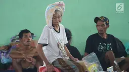 Aktivitas seorang lanjut usia (lansia) di GOR Swecapura, Klungkung, Bali, Senin (27/11). Berdasarkan perkiraan BNPB, ada lebih dari 40.000 warga desa di sekitar Gunung Agung yang telah mengungsi sejak Sabtu, 25 November 2017. (Liputan6.com/Andi Jatmiko)