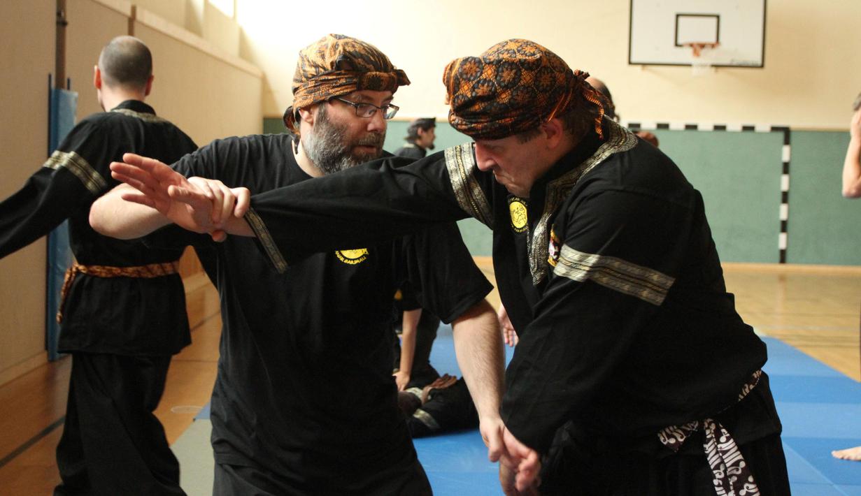 Stefan Taibl (kanan) mengajari tekni silat kepada salah satu murid Anak Harimau yang sudah lanjut usia. (Bola.com/Reza Khomaini)