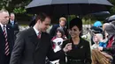 Kate Middleton berjalan bersama suaminya, Pangeran William menggunakan payung usai menghadiri Misa Natal yang digelar secara tradisional bersama keluarga kerajaan di Gereja St. Mary Magdalene di Sandringham, Inggris, (25/12/2015). (AFP/BEN STANSALL)