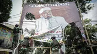 Anggota TNI mencopot paksa baliho Rizieq Shihab yang terpasang di sekitar kawasan Petamburan, Jakarta, Jumat (20/11/2020). Pencopotan dilakukan karena menyalahi aturan yang telah ditetapkan. (Liputan6.com/Faizal Fanani)