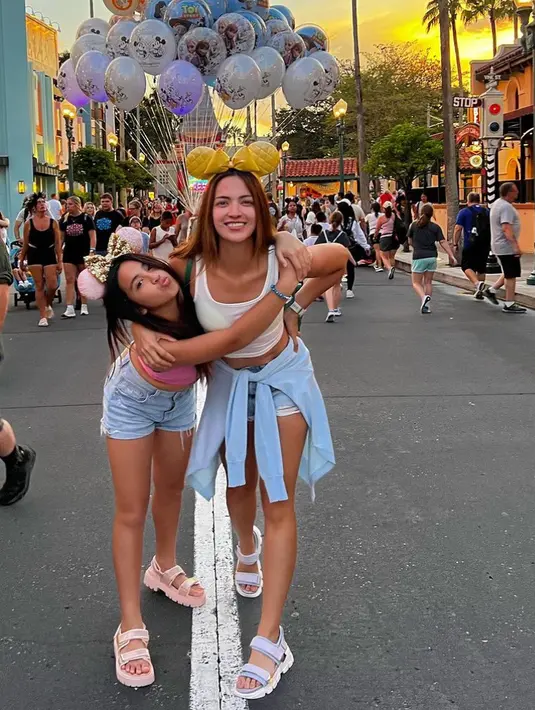 Kedua ibu dan anak bak bestie ini juga tampil santai saat di Disneyland. Mikhayla tampil dengan atasan crop top sleeveless pink dipadukan short pants denim. [@ramadhaniabakrie]