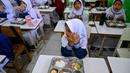 Para siswa berdoa sebelum menyantap makanan yang dipasok oleh program Makan Bergizi Gratis (MBG) di sebuah sekolah dasar, Banda Aceh pada Kamis 30 Oktober 2025. Sejak awal tahun 2025, program Makan Bergizi Gratis (MBG) di Banda Aceh diketahui telah berjalan baik. (CHAIDEER MAHYUDDIN/AFP)
