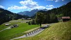 Rombongan pebalap melintas dengan latar belakang pegunungan Alpen Swiss selama etape ke-8 pada ajang balapan sepeda Tour de France 2022. (AFP/Anne-Christine Poujoulat)