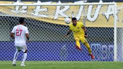 Kiper Dewa United FC, M Natshir Fadhil Mahbuby berusaha menghalau bola pada laga pekan pertama BRI Liga 1 2023/2024 antara Dewa United melawan Arema FC di Stadion Indomilk, Tangerang, Minggu (2/7/2023). (Bola.com/Bagaskara Lazuardi)