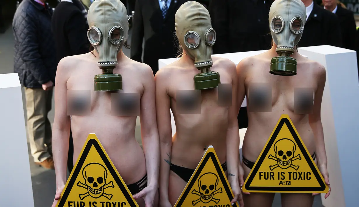 Sejumlah demonstran menggunakan masker gas saat unjuk rasa menolak London Fashion Week, Inggris (19/2). Alasan mereka menolak acara fashion tersebut karena pemakaian bulu binatang dalam pembuatan busananya. (REUTERS / Neil Balai)