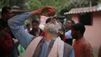 Seorang pria Hindu India minum urin sapi selama acara kelompok agama Hindu untuk mempromosikan konsumsi urin sapi sebagai obat virus corona Covid-19 di New Delhi, India, Sabtu, (14/3/2020). Sekitar 200 orang menghadiri acara minum urin sapi tersebut. (AP Photo/Altaf Qadri)