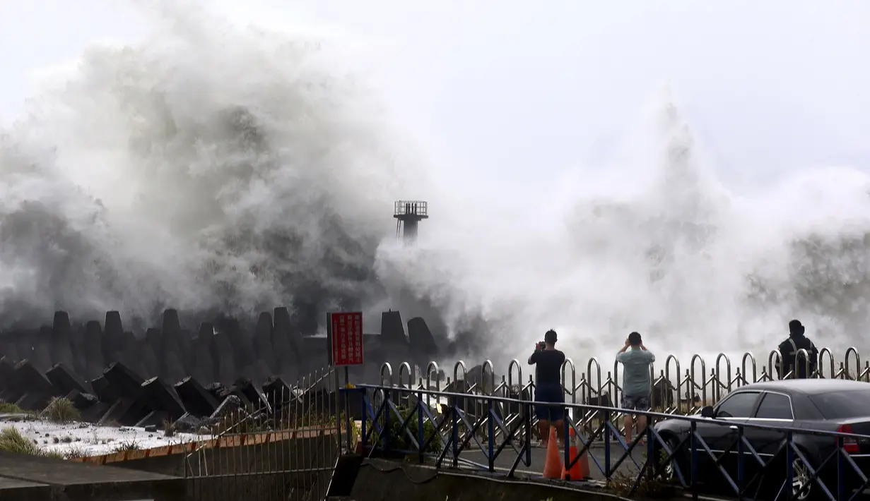 Warga mengambil gambar saat gelombang tinggi menerjangi kota pesisir timur laut Nanfangao saat Topan Soudelor di Ilan, Taiwan, (7/8/2015). Topan ini diperkirakan akan melanda wilayah Taiwan pada hari Sabtu.  (REUTERS/Jerry Chen)