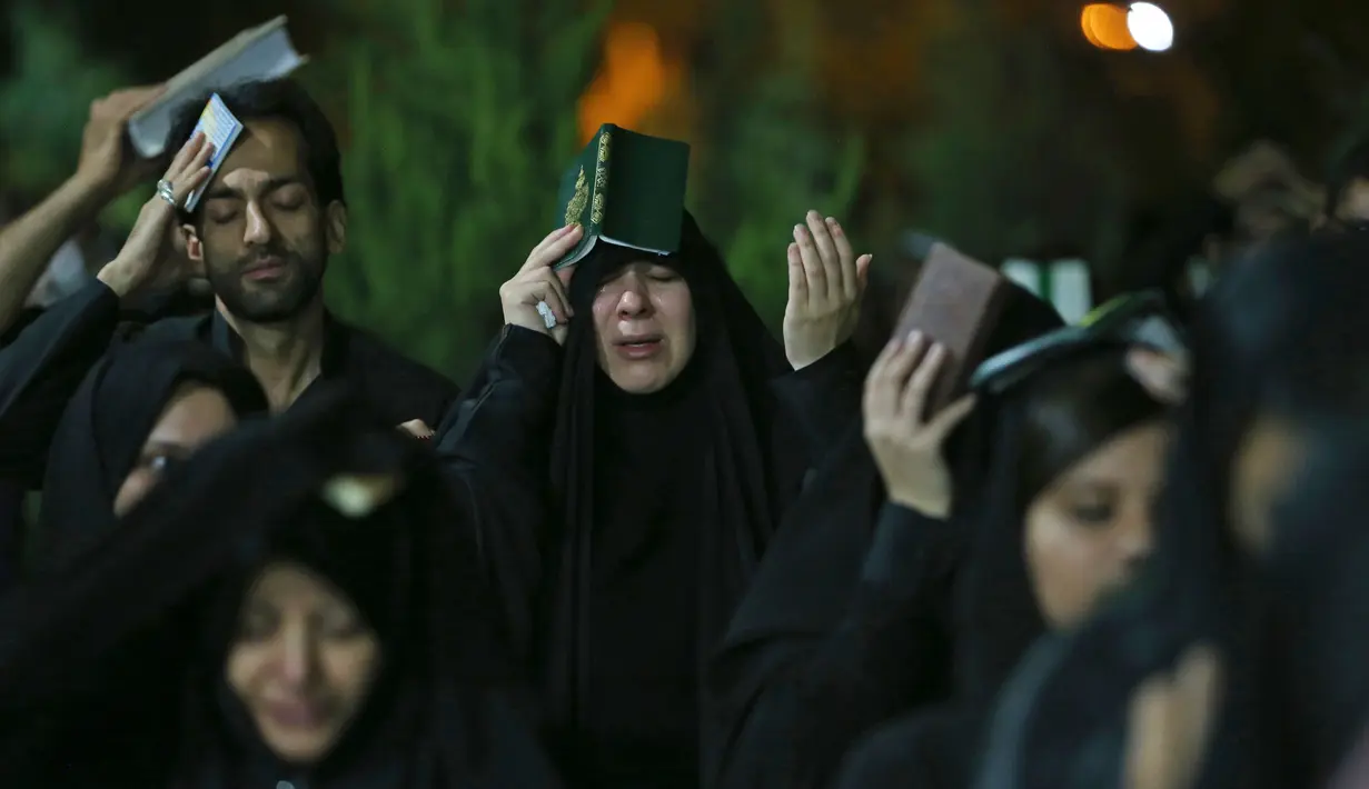 Ekspresi Umat Syiah Iran saat berdoa pada malam Ramadan di Teheran, Iran (16/6). Mereka membaca Al Qura dan berdoa untuk meminta pengampuan. (AP Photo/Vahid Salemi)