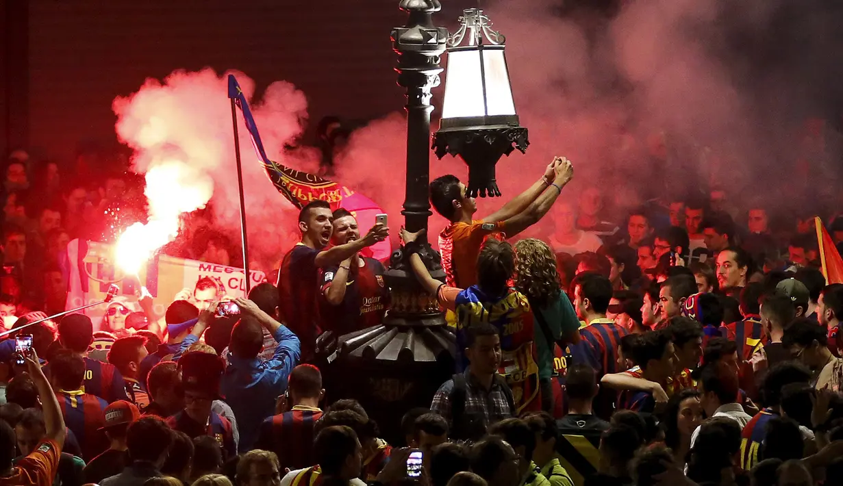 Pendukung Barcelona bergembira ria dan berselfie merayakan keberhasilan tim kesayangan mereka menjuarai Divisi Satu atau La Liga Spanyol di Barcelona, Spanyol (18/5/2015). Barcelona juara setelah mengalahkan Atletico Madrid 1-0. (REUTERS/Gustau Nacarino)