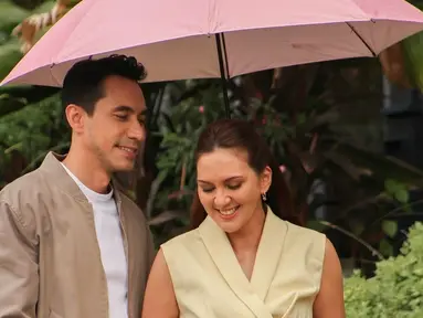 Meski belum pernah main film bareng, Darius dan Donna sudah sering dipasangkan di berbagai iklan. Kali ini, mereka menjadi bintang iklan produk keluarga dengan konsep yang hangat dan manis. Dalam suasana hujan, keduanya tampil mesra di bawah satu payung merah muda. Liputan6.com/IG/@darius_sinathrya)