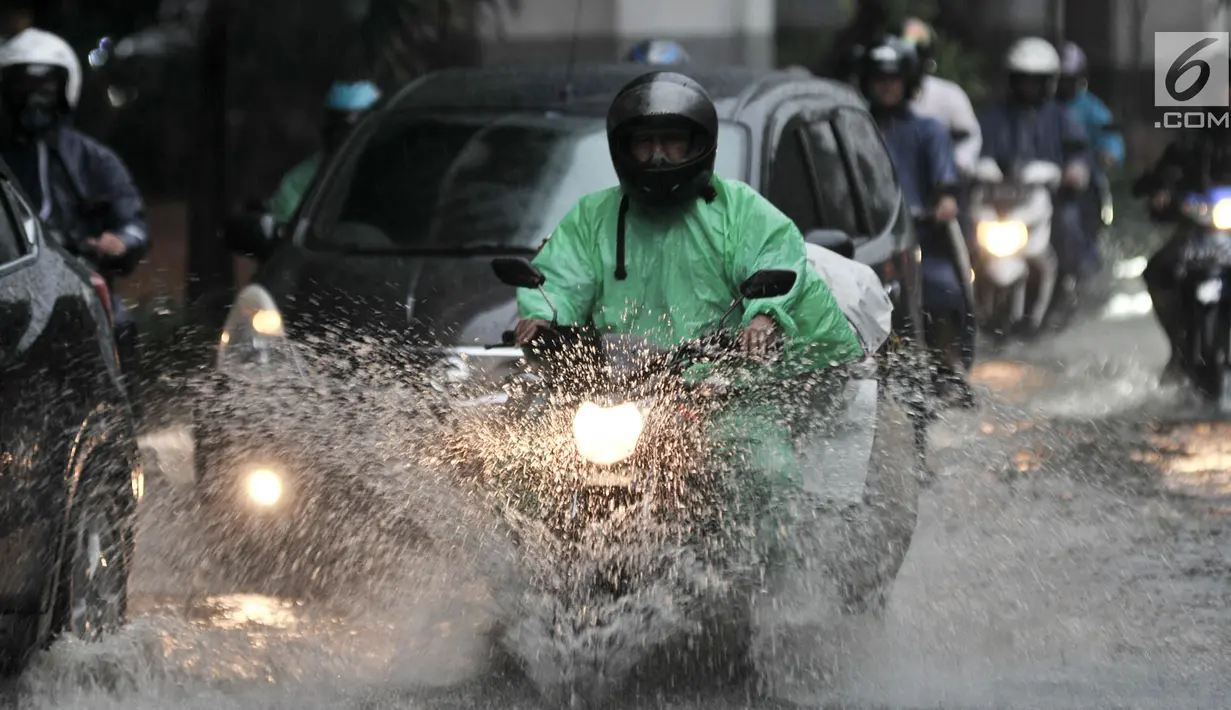 Pengendara sepeda motor menerobos banjir yang menggenangi Jalan DI Panjaitan, Jakarta, Senin (3/12). Hujan deras yang mengguyur Jakarta sejak siang tadi menyebabkan banjir menggenangi hingga sebetis orang dewasa. (Merdeka.com/ Iqbal S. Nugroho)