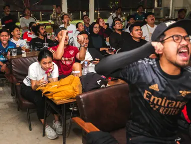 Fans Arsenal melakukan selebrasi saat Bukayo Saka mencetak gol kedua timnya ke gawang West Ham saat Roaring Night Liga Inggris yang berlangsung di Triboon, Cilandak, Jakarta Selatan, Minggu (11/02/2024) malam WIB. (Bola.com/Bagaskara Lazuardi)