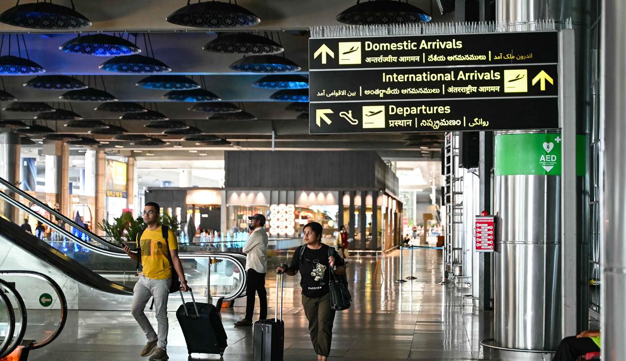Sejumlah otoritas Penerbangan Sipil Umum, termasuk Uni Emirat Arab (UEA) atau General Civil Aviation Authority (GCAA) juga telah mengumumkan penutupan sementara sebagian wilayah udara, seiring meningkatnya aksi militer di Timur Tengah. Tampak dalam foto, para penumpang membawa tas mereka di terminal kedatangan Bandara Internasional Rajiv Gandhi di Hyderabad pada Minggu 1 Maret 2026 ketika dua maskapai penerbangan swasta terbesar India, IndiGo dan Air India, menangguhkan penerbangan ke semua tujuan di Timur Tengah. (Noah SEELAM/AFP)