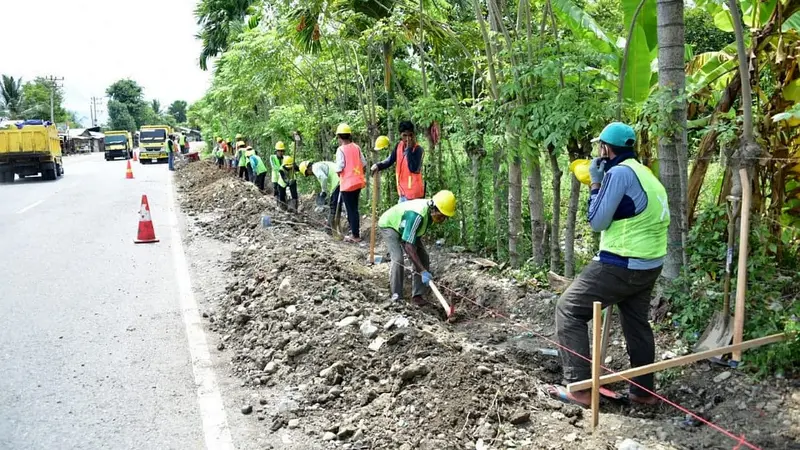 Pekerjaan revitalisasi saluran drainase jalan nasional sepanjang 5.000 Km yang termasuk dalam cakupan program Padat Karya Tunai (PKT). (Dok Kementerian PUPR)