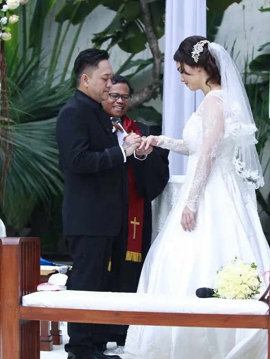Franky Sihombing resmi mempersunting artis cantik Feby Febiola, cincin emas putih disematkan di jari mereka sebagai lambang suci pernikahan. Franky Sihombing dan Feby mengaku bahagia pemberkatan berlangsung lancar. (Galih W. Satria/Bintang.com)