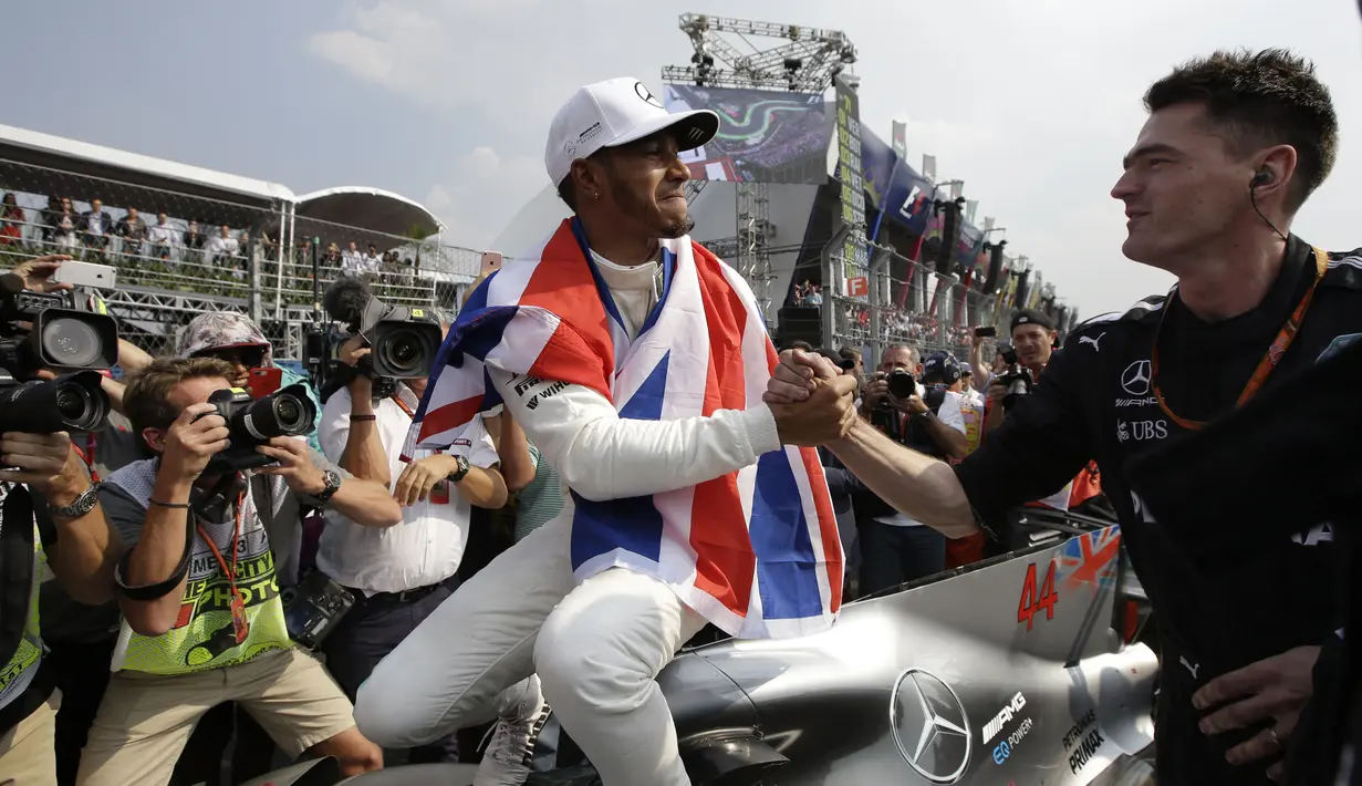 Lewis Hamilton menerima ucapan selamat usai menjadi juara dunia F1 2017 di Hermanos Rodriguez racetrack, Mexico City, (29/10/20170). Hamilton finis kedelapan pada balapan tersebut. (AP/Moises Castillo)