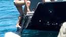 Zac Efron membantu Michelle Rodriguez  untuk naik ke kapal usai menyeburkan diri ke pantai, Pulau Sardinia, Italia, Selasa (8/7/2014) (mzn.com)