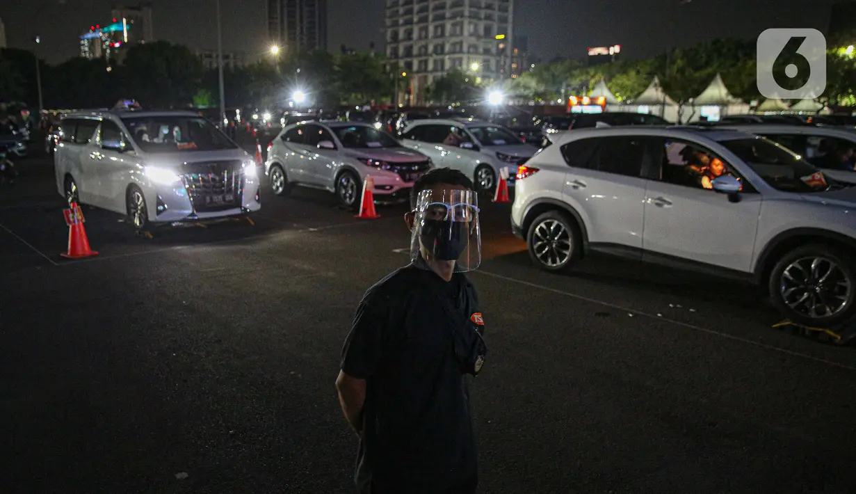 Petugas berjaga saat konser New Live Experience 2020 pada hari kedua di Parkir Barat JIExpo Kemayoran, Jakarta, Minggu (30/8/2020). Konser musik dengan konsep drive-in tersebut digelar dengan menerapkan protokol kesehatan untuk mencegah penyebaran COVID-19. (Liputan6.com/Faizal Fanani)