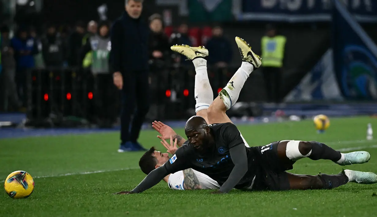 Pemain Napoli, Romelu Lukaku berebut bola dengan pemain Lazio, Alessio Romagnoli dalam laga lanjutan Liga Italia 2024/2025 di Olympic Stadium, Roma, Italia, Minggu (16/02/2025) WIB. (AFP/Filippo Monteforte)