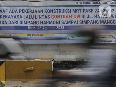 Spanduk pemberitahuan terkait penerapan rekayasa lalu lintas lawan arah atau contraflow terpasang di Jalan Gajah Mada, Jakarta, Kamis (31/8/2023). (Liputan6.com/Herman Zakharia)