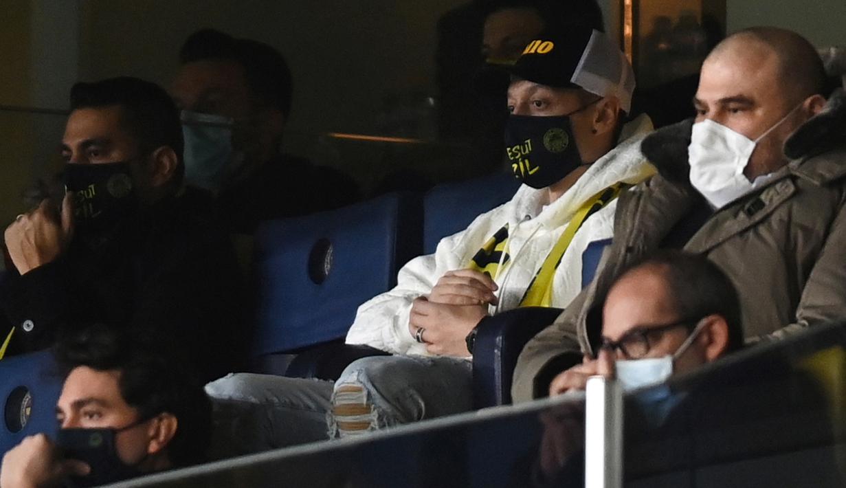 Pemain anyar Fenerbahce, Mesut Ozil menyaksikan pertandingan timnya melawan Kaysersispor dari bangku penonton dalam lanjutan Turkish Super League di Istanbul, Senin (25/1/2021). (Foto: AFP/Ozan Kose)