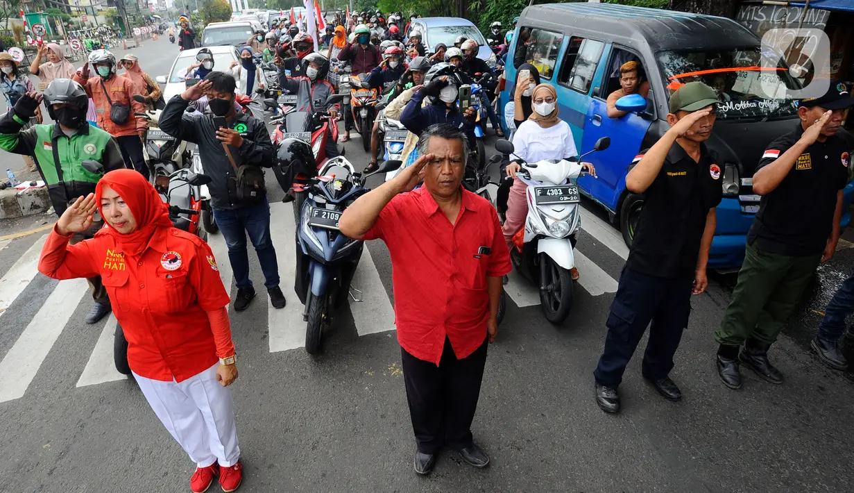 Warga bersama pengguna jalan melakukan penghormatan saat detik-detik proklamasi 17 Agustus di ruas jalan protokol Jakarta-Bogor, pertigaan Cibinong, Bogor, Jawa Barat, Rabu (17/8/2022). Sejumlah pengguna jalan terlihat turun dari kendaraannya dan melakukan sikap hormat. (merdeka.com/Arie Basuki)