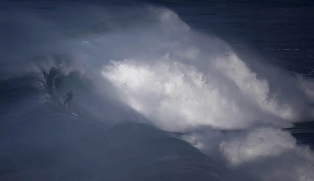 Ombak Besar mengulung pesalancar Garrett McNamara di Praia do Norte, Nazare, Portugal, (13/11).Nazare Canyon memiliki kedalaman lebih dari 3 mil di bawah permukaan sehingga mampu menaikkan gelombang setinggi 100 sampai 150 kaki. (REUTERS/Rafael Marchante)