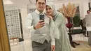 Tommy Kurniawan dan istri juga bertugas tampil twinning. Dress hijab sang istri dengan aksen tulle menambah gaya ekstra ke pesta. [Foto: Instagram @tommykurniawan]