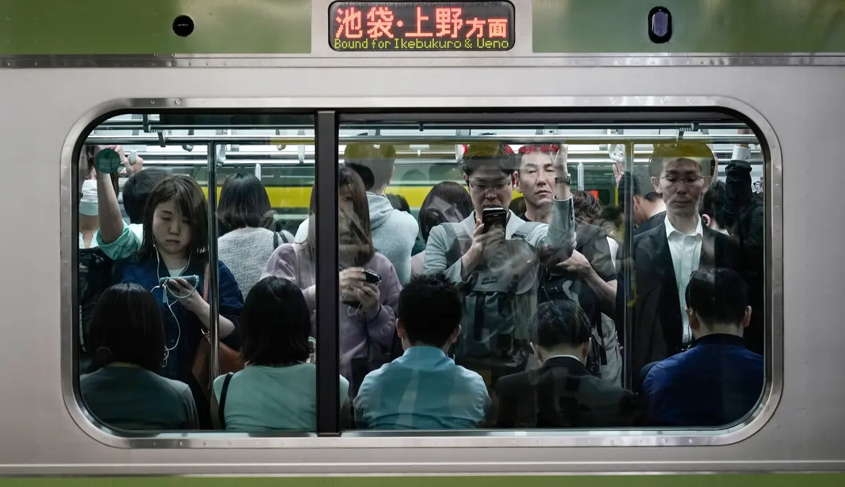 Penumpang menaiki kereta Yamanote Line yang penuh sesak di Stasiun Shinjuku, Tokyo, Jepang, Sabtu (25/5/2019). (AP Photo/Jae C. Hong)