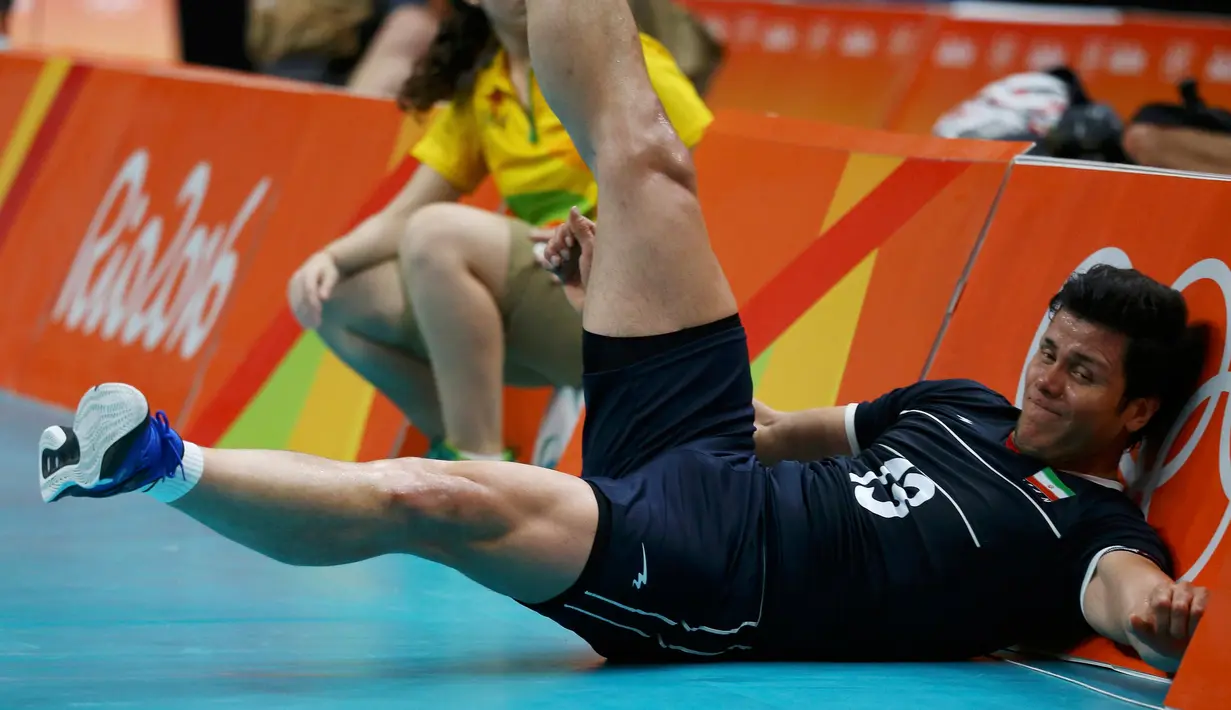 Pemain voli asal Iran, Mehdi Mahdavi terjatuh saat laga melawan Polandia di Olimpiade Rio 2016, Brasil pada 9 Agustus 2016. (REUTERS/ Marcelo del Pozo)