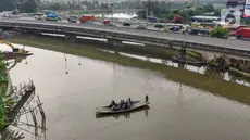 Pengendara sepeda motor menggunakan jasa perahu eretan menyeberangi Sungai Kali Angke di Kecamatan Penjaringan, Jakarta, Rabu (29/5/2024). (merdeka.com/Arie Basuki)