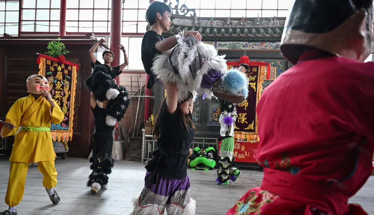 Dengan mengenakan celana panjang berpayet berbulu dan atasan hitam, Lin Xinmeng menjadi bagian dari pemain dalam tarian barongsai. (Jade GAO/AFP)