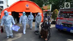Petugas mengevakuasi pasien COVID-19 untuk menjalani perawatan di dalam tenda darurat di RSUD Kota Bekasi, Jumat (25/06/2021). Puluhan pasien covid-19 saat ini dirawat dalam tenda darurat karena keterisian tempat tidur yang penuh akibat lonjakan kasus. (merdeka.com/Arie Basuki)