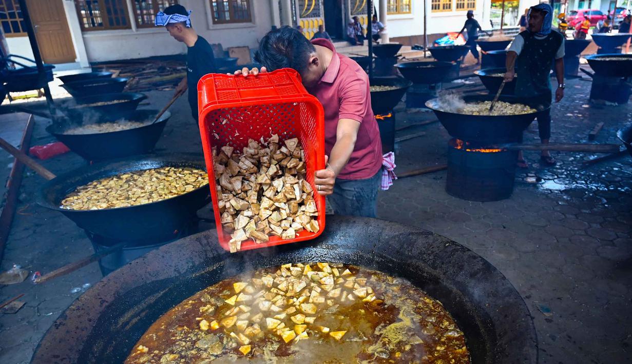 Para pria memasak hidangan kari tradisional yang disebut 'kuah beulangong' untuk dibagikan saat berbuka puasa, sekaligus memperingati turunnya Al-Quran selama bulan suci Ramadan, di Banda Aceh pada Sabtu 7 Maret 2026. Kuah Beulangong merupakan kuliner legendaris khas Aceh yang menjadi tradisi penting selama bulan Ramadan, terutama di wilayah Aceh Besar dan Banda Aceh. (CHAIDEER MAHYUDDIN/AFP)