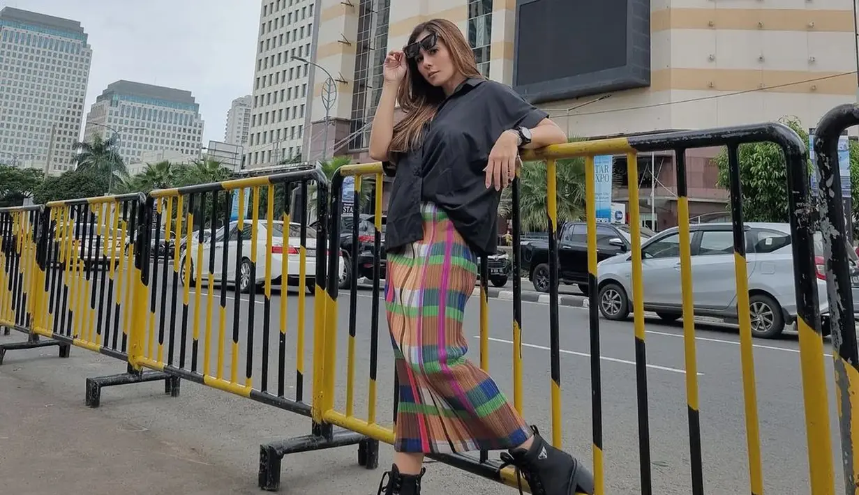 <p>Jika bosan dengan busana minimalis, kamu bisa sedikit stand out dengan motif kotak-kotak. Wulan Guritno sendiri memadukan oversized black shirt dengan rok kotak-kotak warna warni. Outfit ini terlihat begitu edgy dengan boots tinggi. (instagram/wulanguritno)</p>