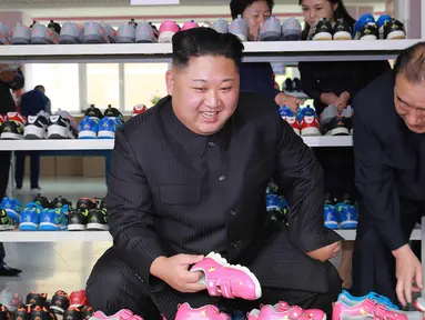 Pemimpin Korea Utara Kim Jong-Un mengecek sepatu saat mengunjungi pabrik sepatu Ryuwon di Pyongyang 19 Oktober 2017. (AFP Photo/KCNA Via KNS/Str/South Korea Out/Republic Of Korea Out)