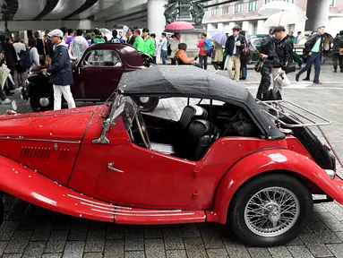 Sejumlah pengunjung melihat mobil antik dan klasik yang dipamerkan dalam acara Japan Classic Automobile 2017 di jembatan Nihonbashi di Tokyo, Jepang (9/4). (AFP/Toshifumi Kitamura