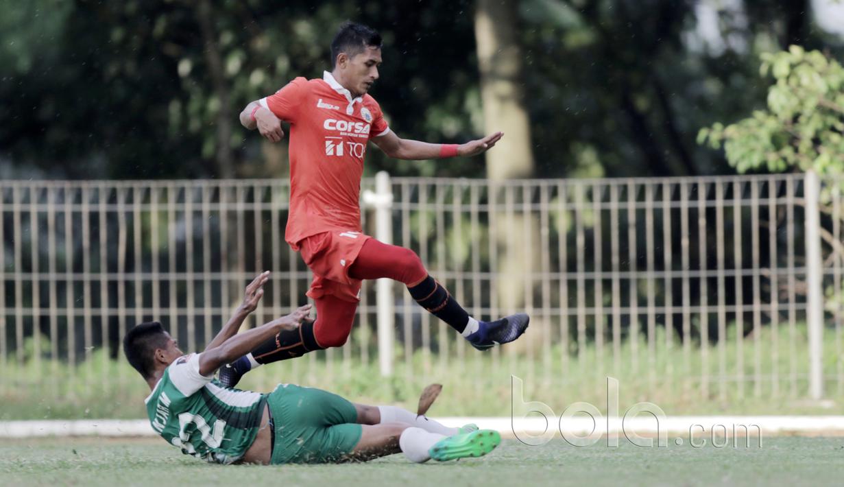 Pemain PS TNI, Ganjar menghalau bola dari kaki pemain Persija Jakarta, Rudi Widodo pada laga uji coba di GOR Ahmad Yani, Cilangkap, Minggu (9/4/2017). PS TNI bermain imbang lawan Persija. (Bola.com/Nicklas Hanoatubun)