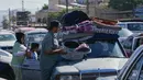 Para pengungsi mengemasi barang-barang mereka saat bersiap untuk kembali ke desa mereka setelah pengumuman kesepakatan gencatan senjata awal antara Amerika Serikat dan Iran, di kota pelabuhan selatan Sidon, Lebanon, Senin 15 Juni 2026. (AP Photo/Mohammed Zaatari)